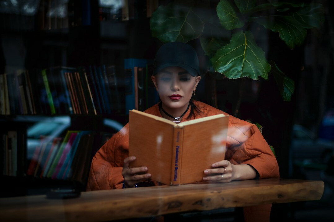 woman reading mystery book at night